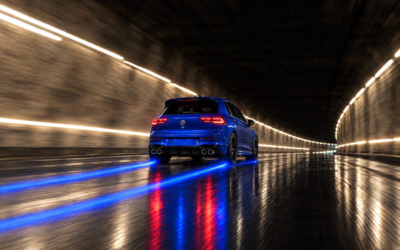 A blue Volkswagen Golf under the lights of a tunnel